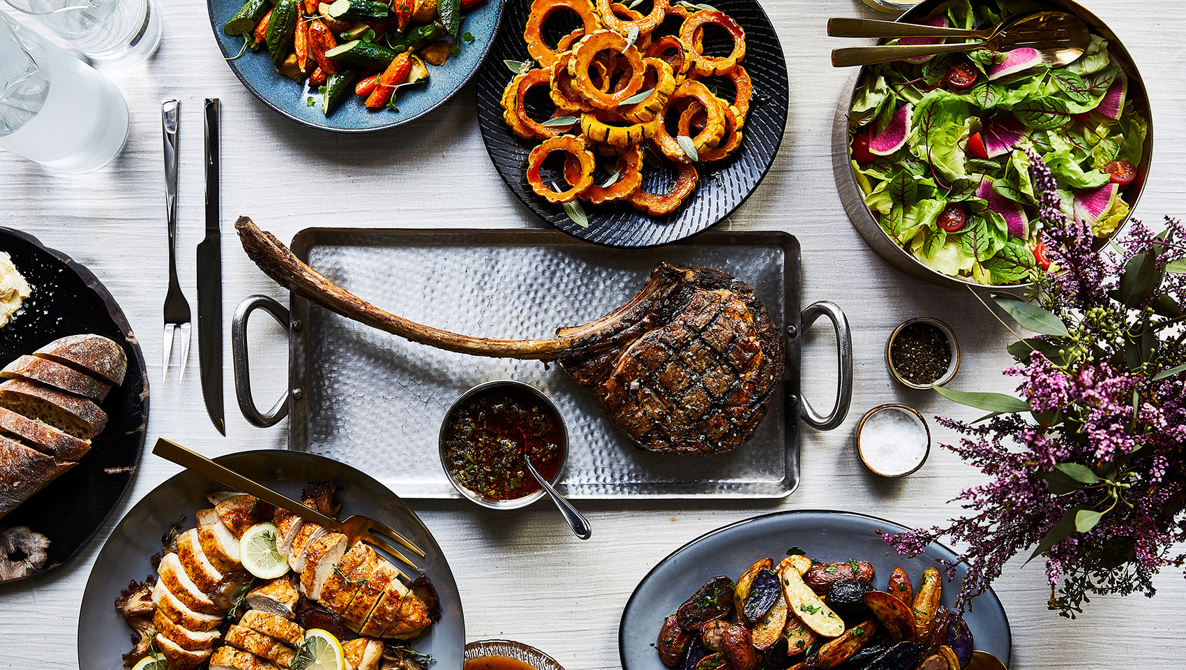 Variety of plated food including a tomahawk steak