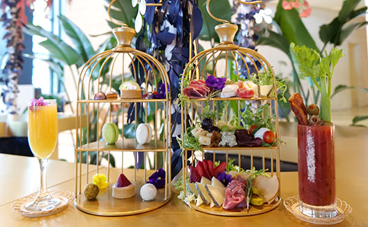 cocktails and assorted desserts in a bird cage display